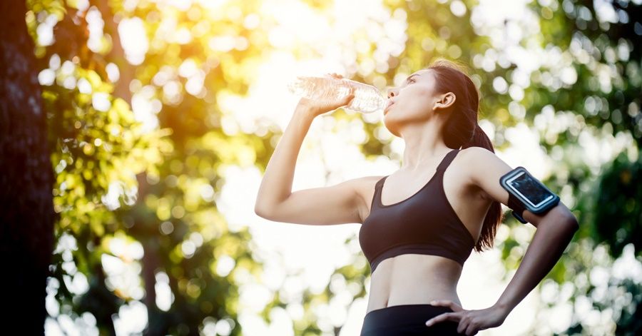 Fitness woman athlete takes a break, Drinking water, Hot day. Co