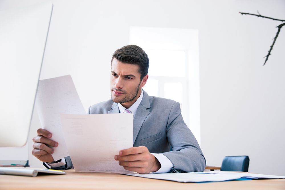 Businessman reading papers in office