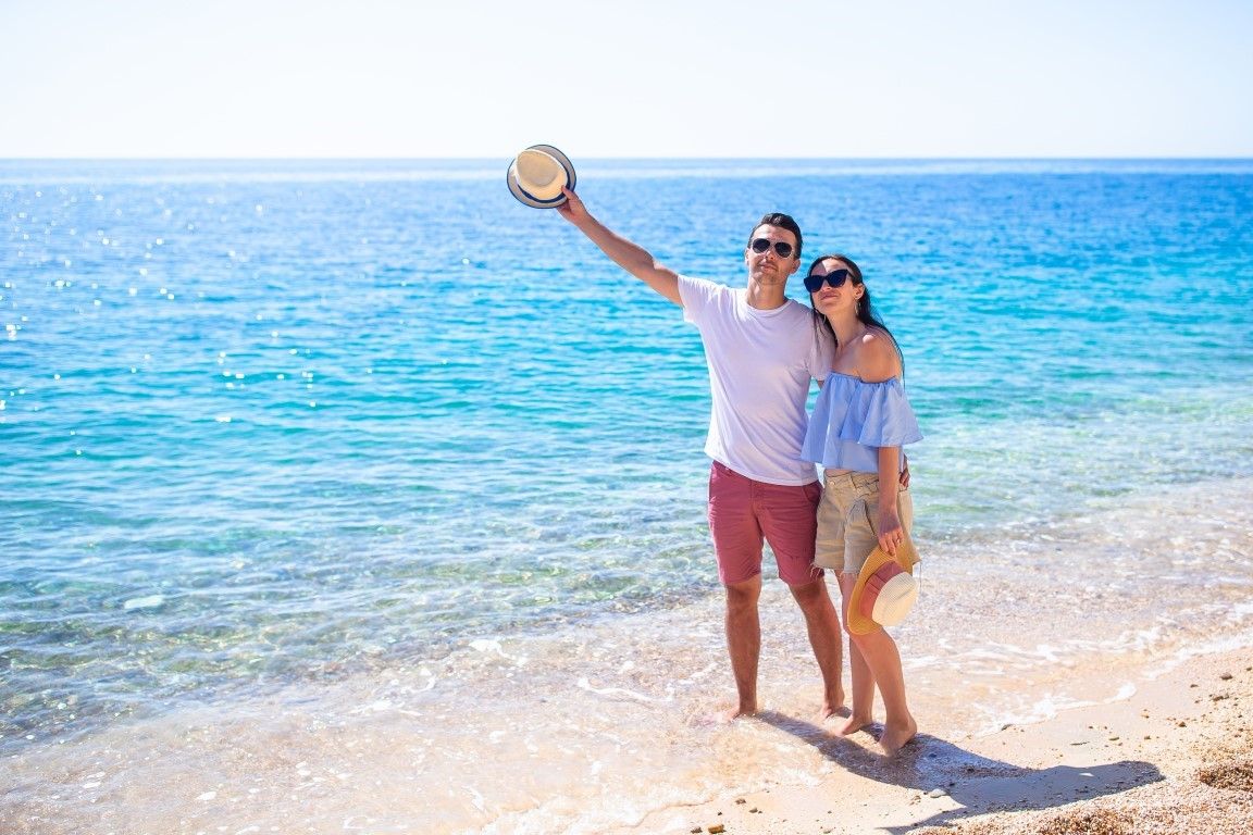 picture of happy couple in sunglasses on the beach